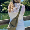 Woman wearing Stringfield Sling bag in pine color.