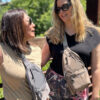 one woman with grey Stringfield sling bag talking to another with woman with a hazelnut Stringfield sling bag.